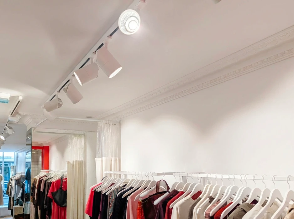Boutique de prêt-à-porter, intérieur blanc épuré avec moulures en staff au plafond
